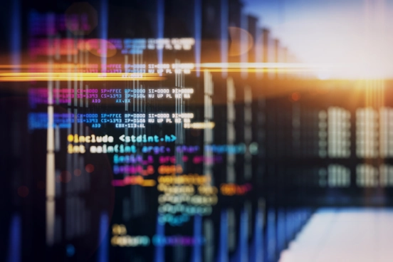 Une image stylisée d’un code informatique multicolore superposée à une image de racks de serveurs dans un centre de données