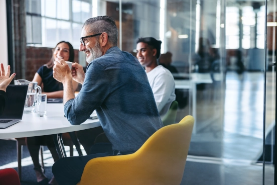 Une photo de trois personnes travaillant autour d’un bureau