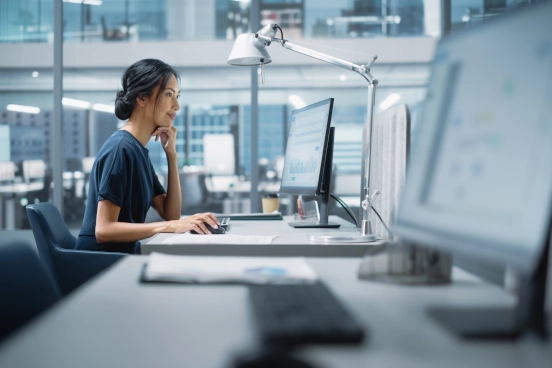 Une photographie d’un professionnel de la santé assis à un bureau utilisant un ordinateur personnel.